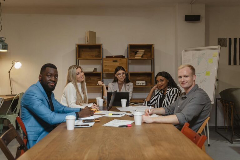 A diverse group of professionals engaged in a productive meeting in a contemporary office environment.